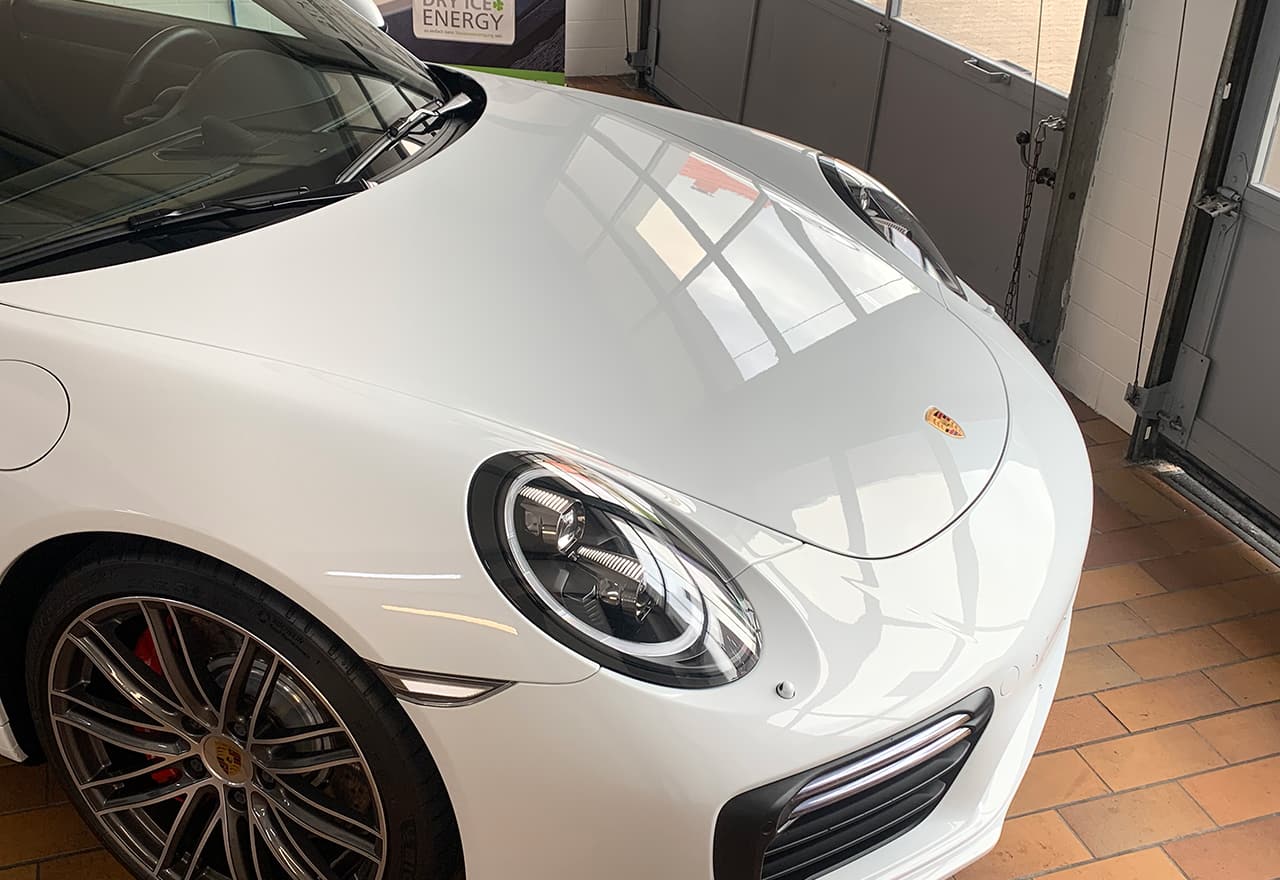 weißer Porsche während Fahrzeugaufbereitung bei Sostar